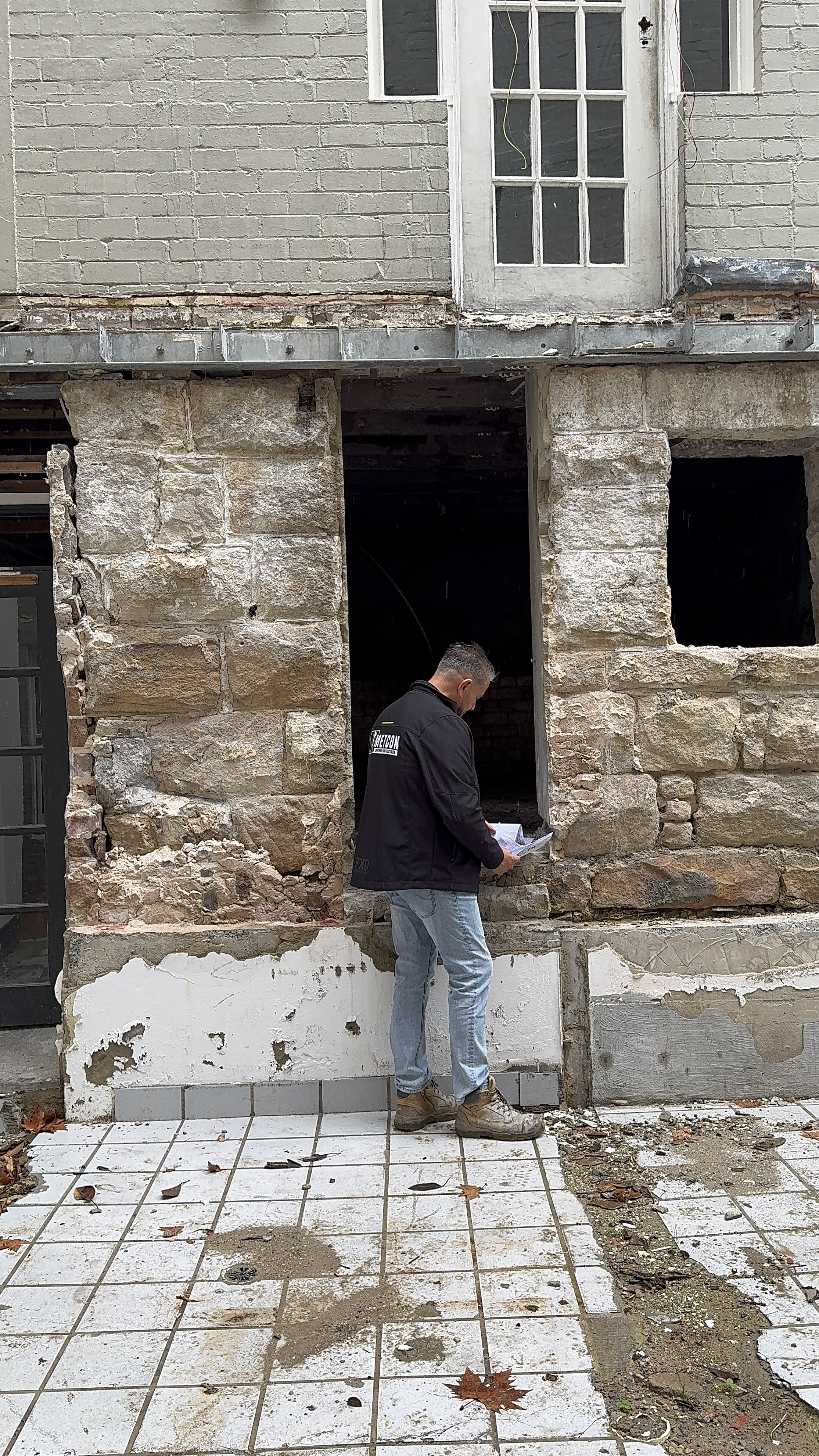 METCON team member inspecting heritage sandstone facade