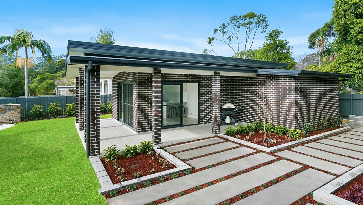Completed single storey brick residential build with landscaped yard
