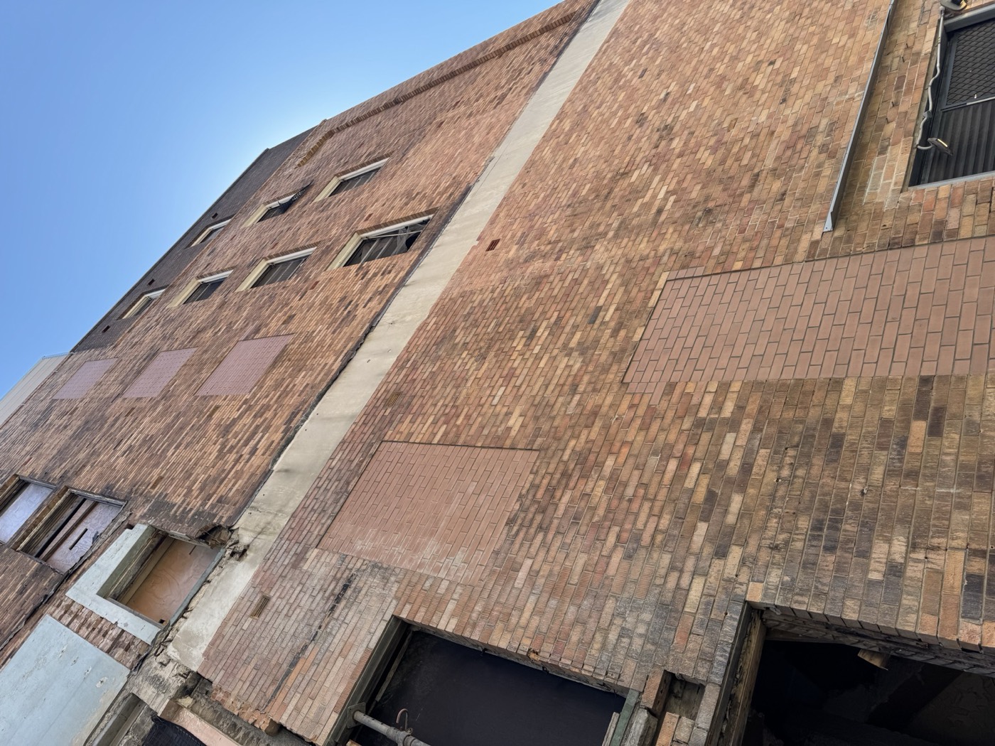 Multi-storey face brick facade with infilled openings