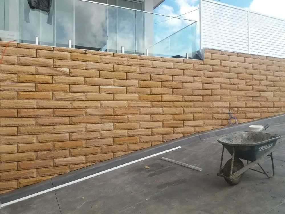 Sandstone-clad retaining wall over a structural core